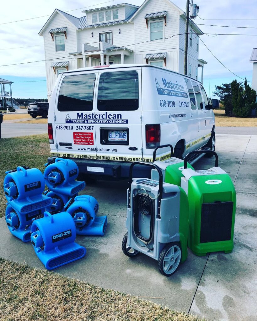 Masterclean van with air movers and a dehumidifier outside a coastal home